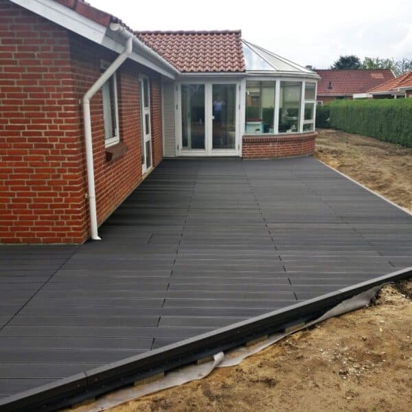 Kompositterrasse i gråsort massiv komposit med riller. Vedligeholdelsesfri terrassebrædder. Skridsikre terrassebrædder