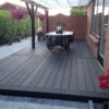 Massiv komposit terrasse i vedligeholdelsesfri gråsort komposit med træstruktur. Helforbant