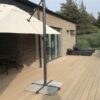Vedligeholdelsesfri terrasse i massiv komposit lys eg med riller. Oak kompositterrasse ved gul brunt hus