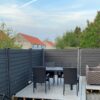 Havehegn og terrasse i vedligeholdelsesfrit gråsort / betongrå komposit. Galvaniserede u-skinner og komposit stolper