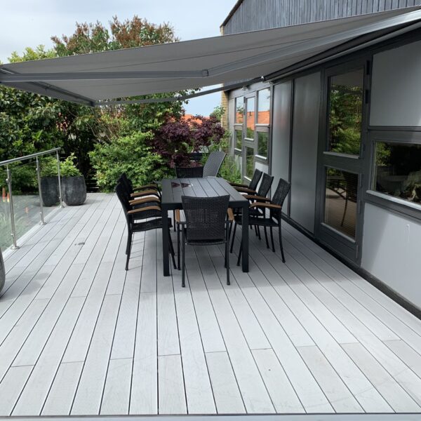 Komposit terrasse massiv betongrå med riller. Terrasse med trin. Hævet terrasse med gelænder