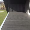 Massive komposit terrassebrædder med træstruktur. Vedligeholdelsesfri komposit terrasse på altan. Sort terrassebelægning