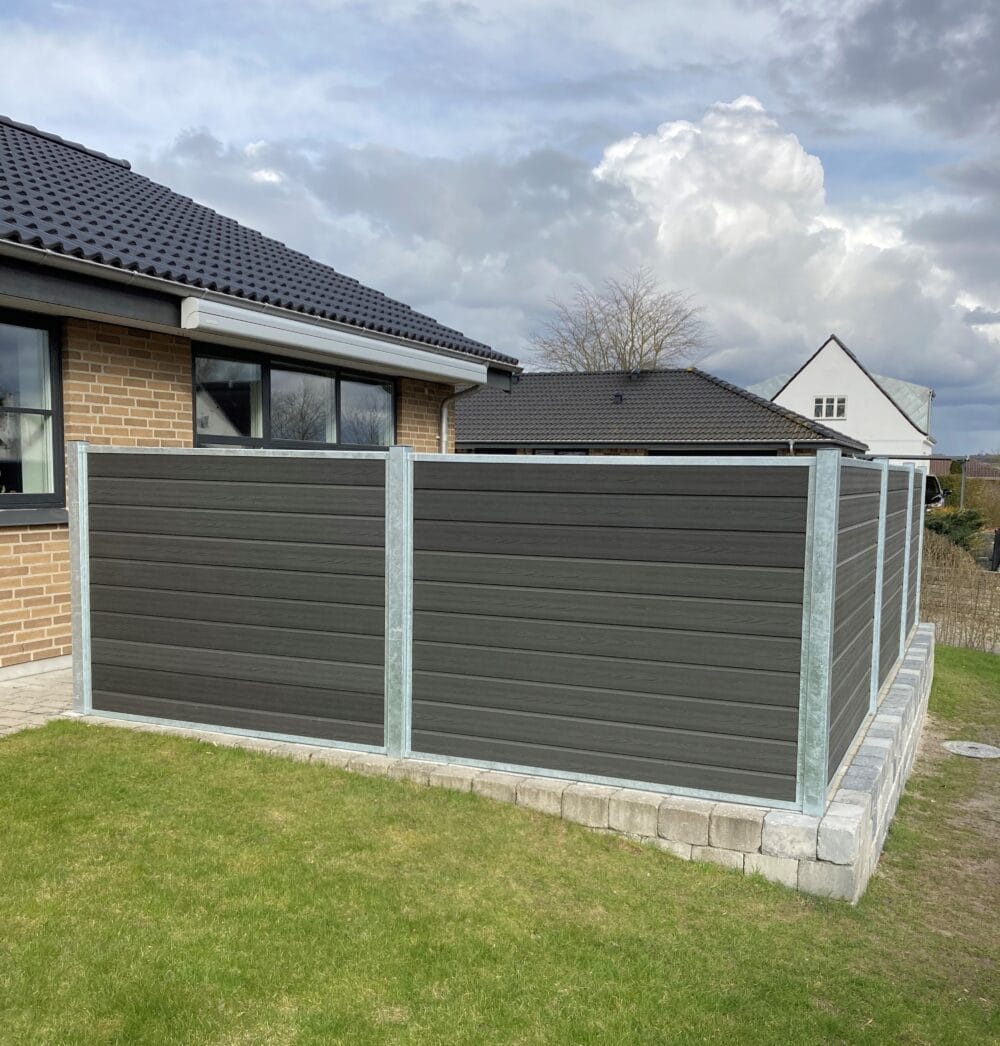 Vedligeholdelsesfrit komposithegn i gråsort med træstruktur. Terrasse hegn. Galvaniserede stålstolper og hegnsbrædder med fer og not