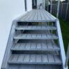 Komposit trappe og repos i massiv betongrå komposit med træstruktur. Stålterrasse med kompositbelægning